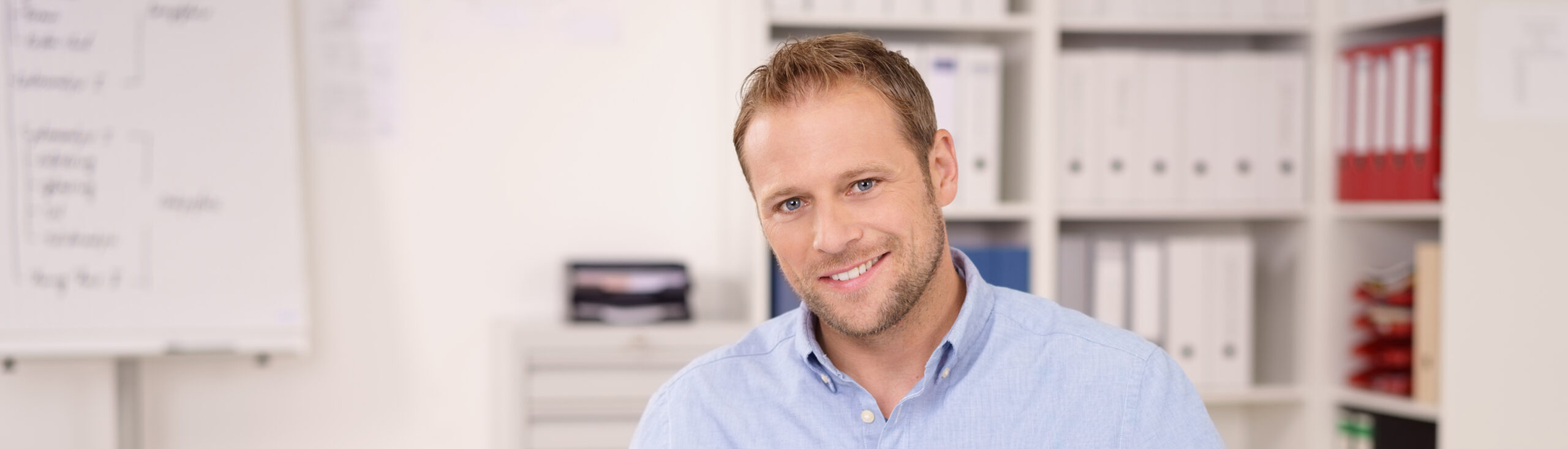 Mann mit Laptop om Büro