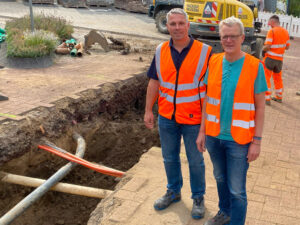 Das Foto zeigt die Nahwärmebaustelle mit zwei Mitarbeitern.