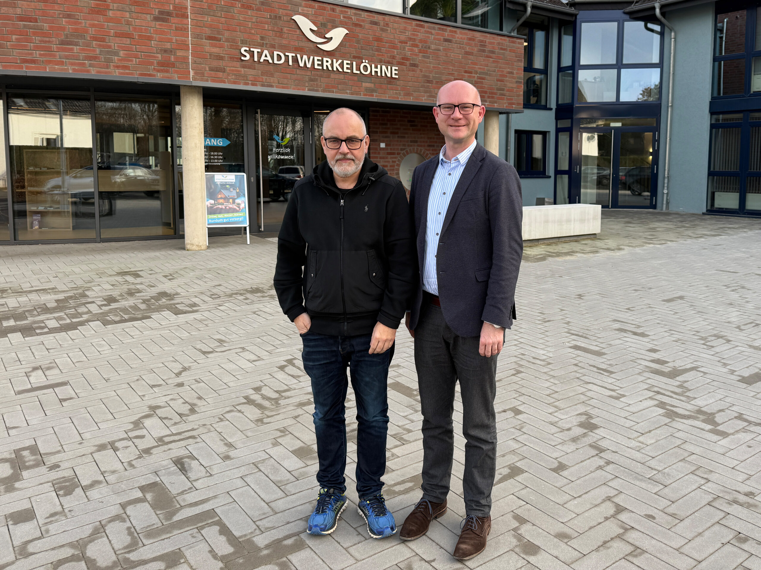 Geschäftsführer und Bürgermeister stehen vor den Stadtwerken