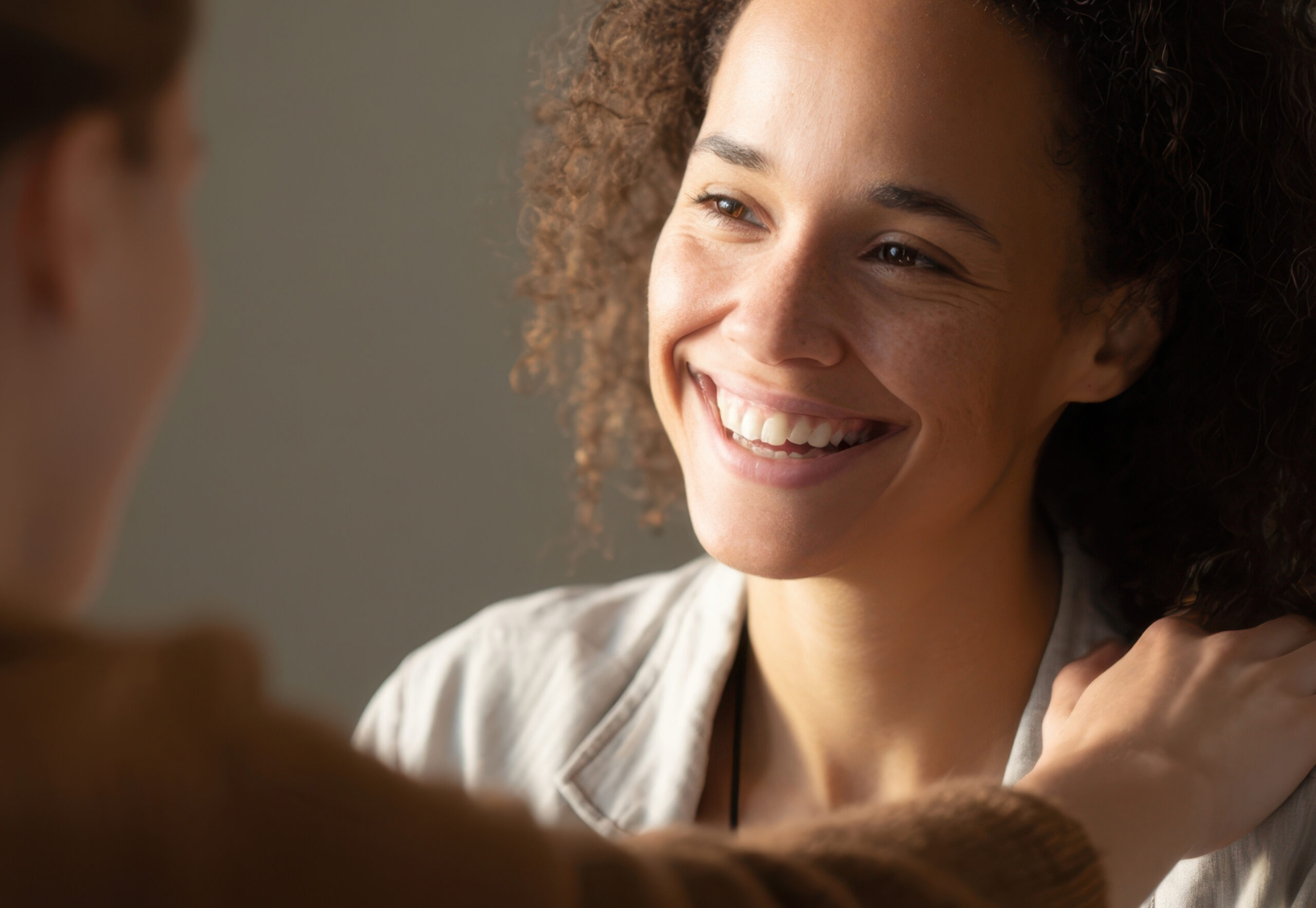 Eine Frau legt die Hand auf die Schulter einer anderen Frau.