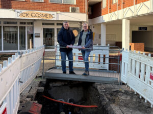 Zwei Mitarbeiter stehen vor einer Nahwärme Baustelle.