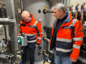 Im Technikraum wird die Wärmeübergabestation begutachtet.